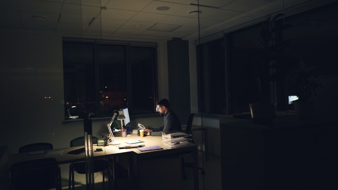 Entrepreneur using AI tools on a laptop at a dark minimalist desk